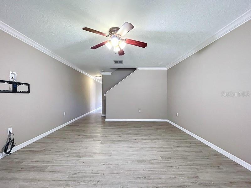 37615 Daliha Terrace Zephyrhills, FL 33542 - Photo 9 of 16 a view of an empty room with wooden floor and a ceiling fan