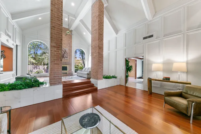a living room with furniture fireplace and a large window