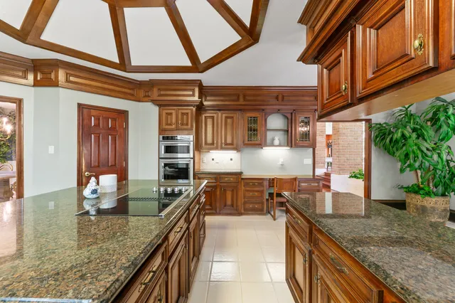 a kitchen with stainless steel appliances granite countertop a stove and a dining table with chairs