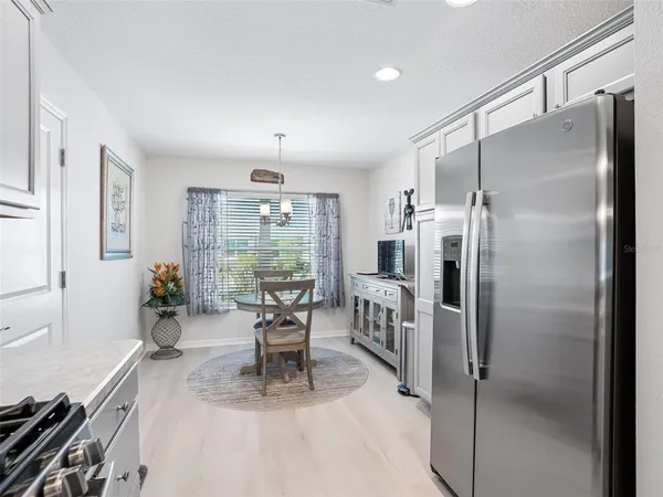 a kitchen with stainless steel appliances granite countertop a refrigerator sink and white cabinets