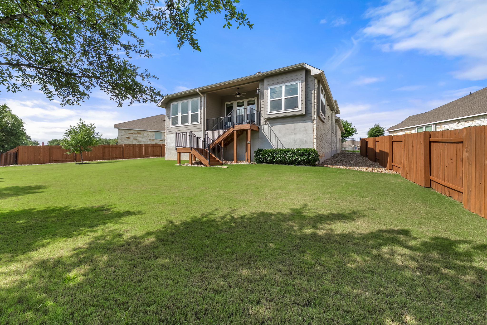 300 Prato Place Georgetown, TX 78628 - Photo 34 of 40 A vibrant green lawn extends to a charming house, complete with a private fenced yard and outdoor deck.