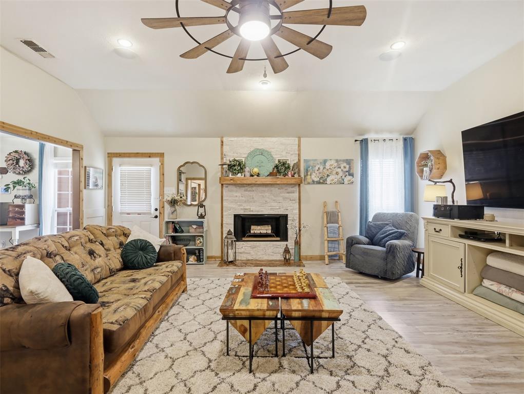 3823 State Highway Bonham, TX 75418 - Photo 25 of 37 a living room with furniture a flat screen tv and a fireplace
