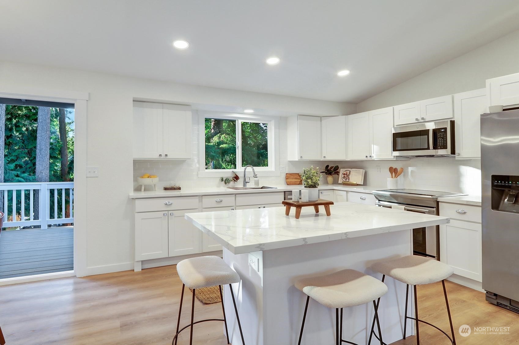 2029 Timber Trail Bothell, WA 98012 - Photo 3 of 24 a kitchen with stainless steel appliances granite countertop a stove top oven a sink a refrigerator with a dining table and chairs with wooden floor