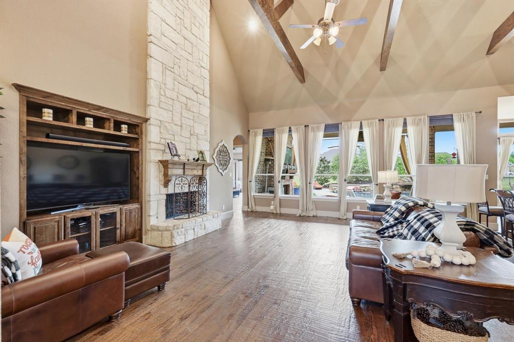 406 Spurgin Road Lucas, TX 75002 - Photo 6 of 39 Living area featuring a stone fireplace, lofted ceiling, ceiling fan, and wood-type flooring