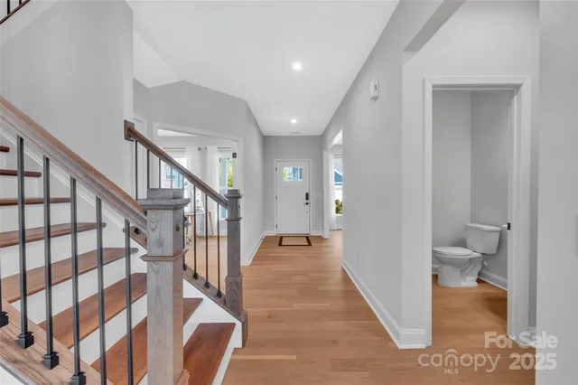 a view of a hallway with wooden floor and stairs