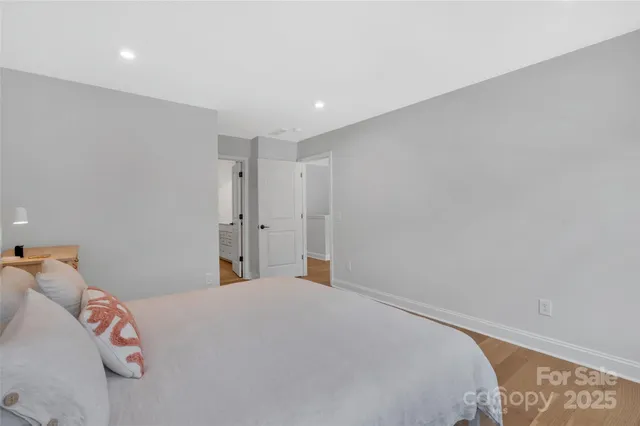 a bedroom with a large bed and a chandelier