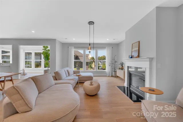 a living room with furniture a fireplace and a chandelier