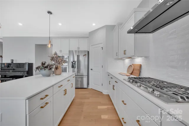 a kitchen with white cabinets and appliances