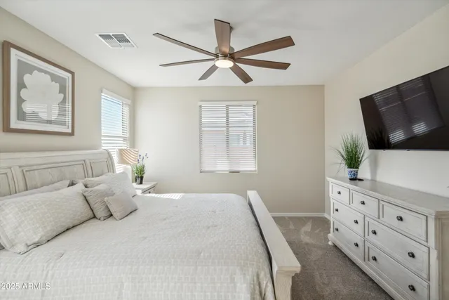 a bedroom with a large bed and a flat tv screen on dresser