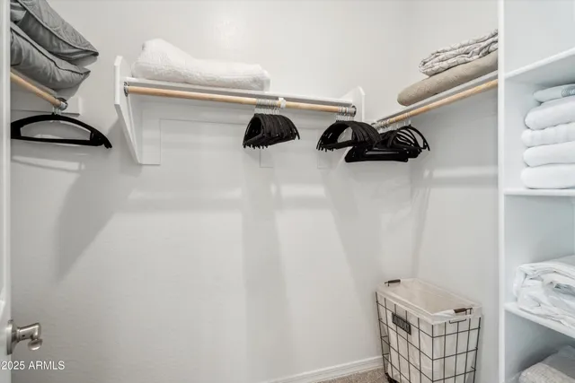 a view of walk in closet with clothes and shoes