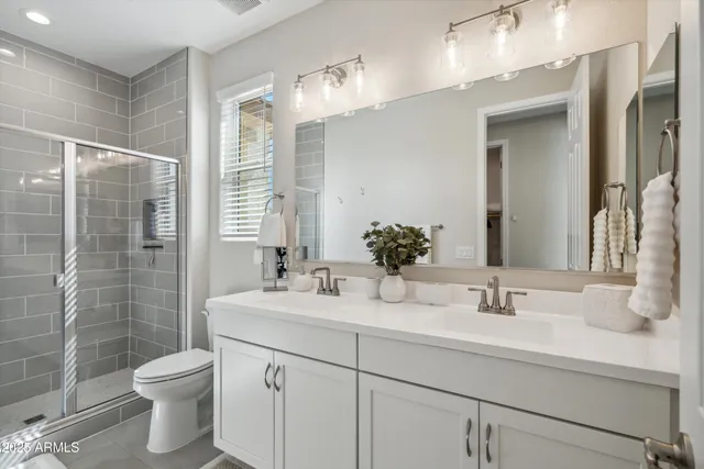 a bathroom with a double vanity sink toilet and shower