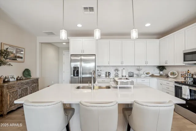 a kitchen with a sink a stove a refrigerator and cabinets