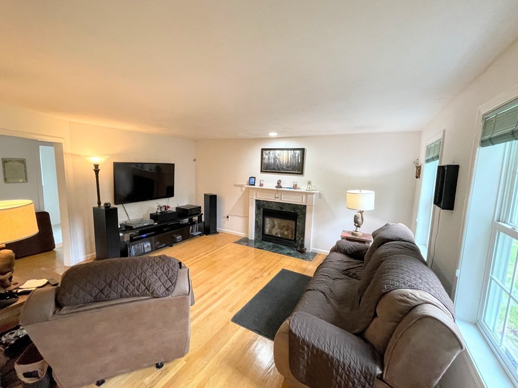 149 Groton Road Shirley, MA 01464 - Photo 9 of 32 a living room with furniture a flat screen tv and a fireplace
