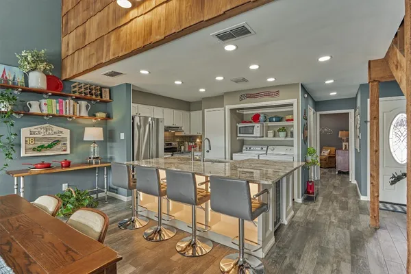 a kitchen with stainless steel appliances granite countertop a sink refrigerator and cabinets