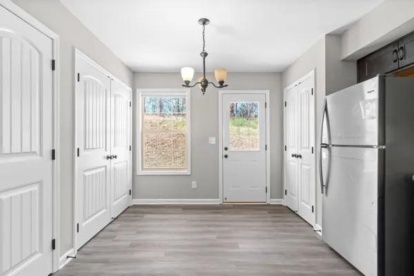 a view of a hallway with wooden floor and stairs