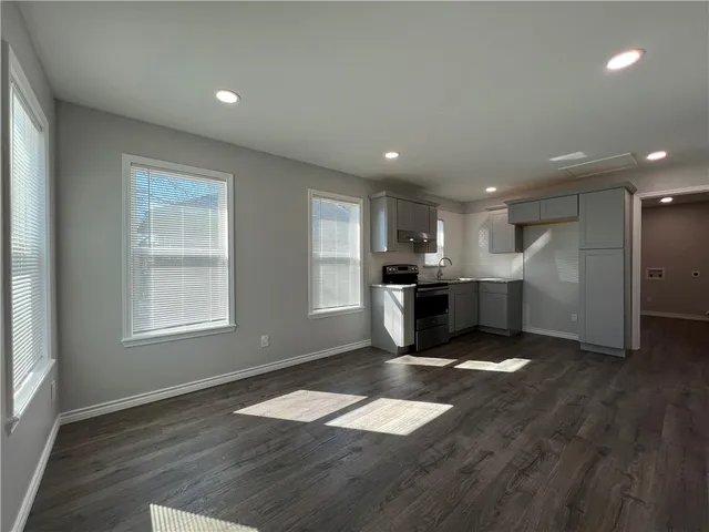 a open kitchen with stainless steel appliances granite countertop a refrigerator stove top oven and cabinets