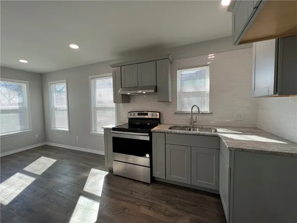 a kitchen with stainless steel appliances granite countertop a sink stove and cabinets