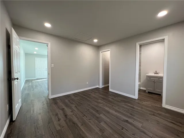 a view of a room with wooden floor and a bathroom