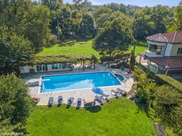 an aerial view of a house with swimming pool patio and outdoor seating