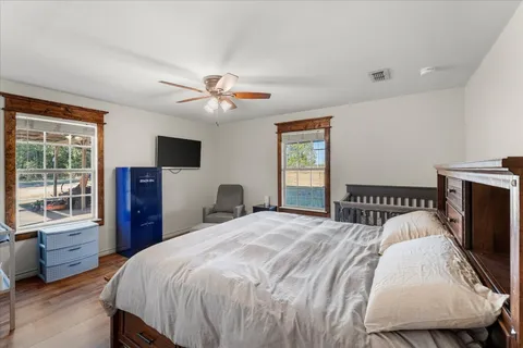 a bedroom with a bed a dresser and flat screen tv