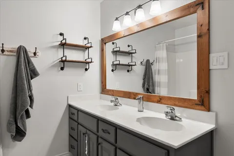 a bathroom with a sink vanity and a mirror
