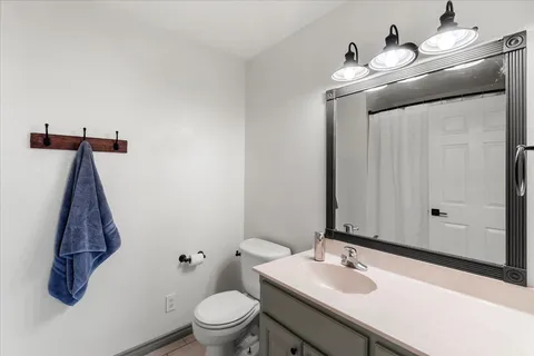 a bathroom with a sink a toilet and mirror