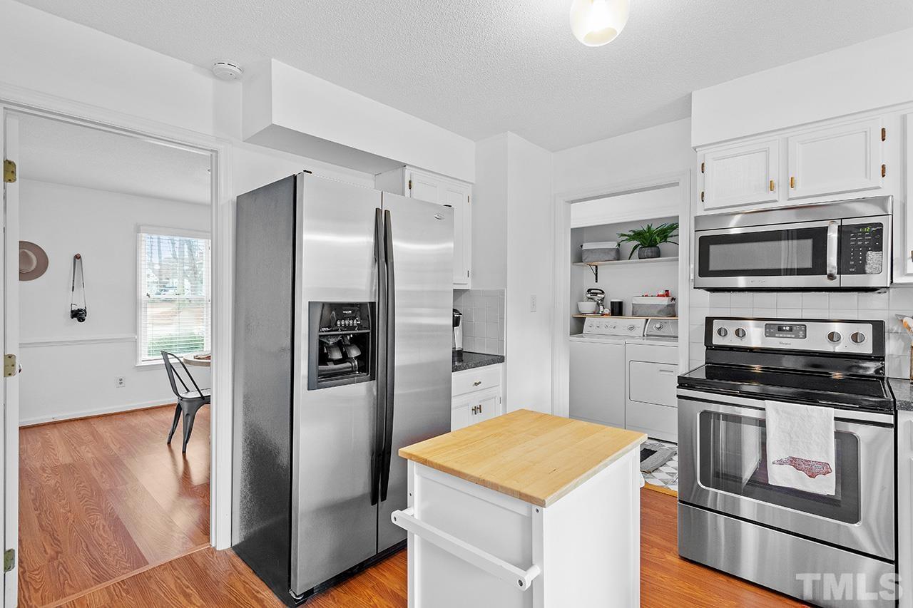 4428 Liverpool Lane Raleigh, NC 27604 - Photo 7 of 24 a kitchen with stainless steel appliances kitchen island granite countertop a refrigerator stove and sink