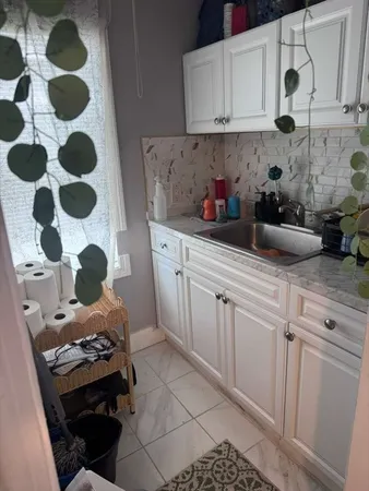 a kitchen with a sink a stove and cabinets