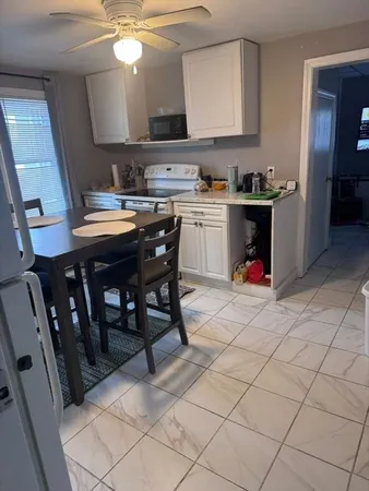 a kitchen with a sink a stove and chairs