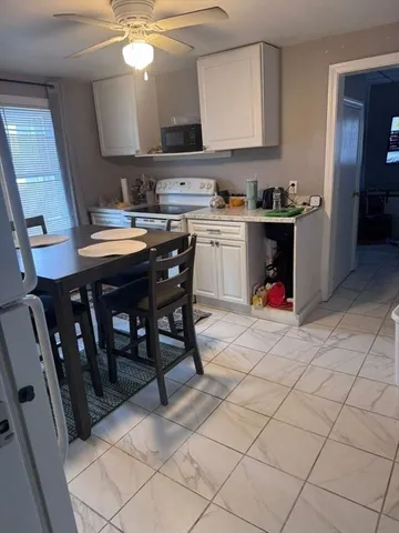 a kitchen with a sink a stove and chairs