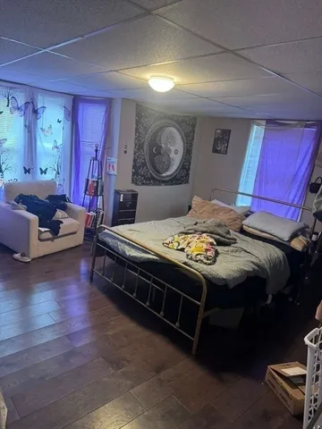 a bedroom with a bed and wooden floor