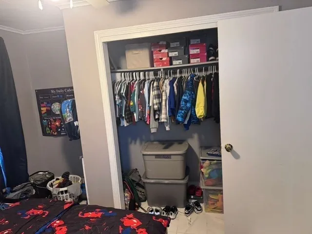 a view of walk in closet with clothes and shoes