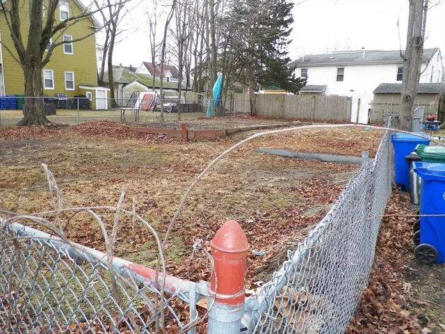 a backyard of a house with large trees and outdoor seating