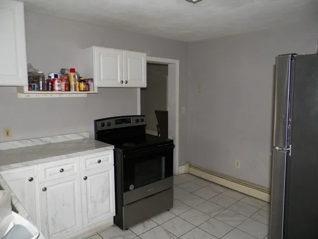 a kitchen with white cabinets and black appliances