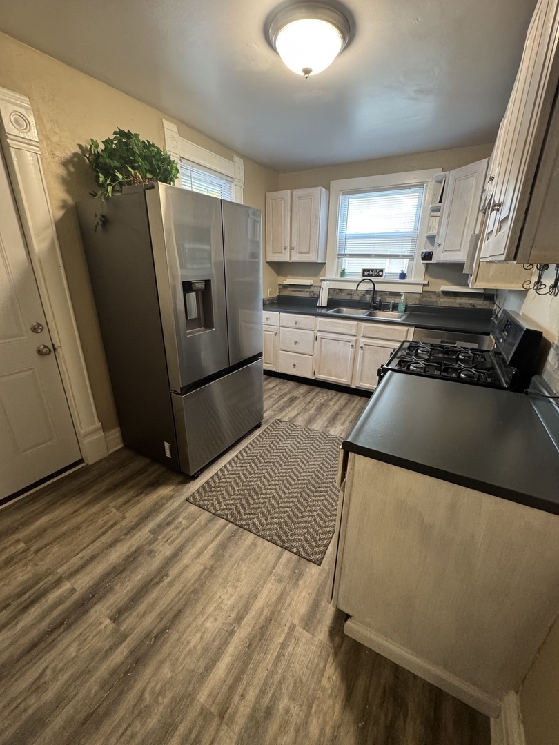1108 East Main Street Urbana, IL 61802 - Photo 4 of 10 a kitchen with stainless steel appliances granite countertop a refrigerator a stove and a sink