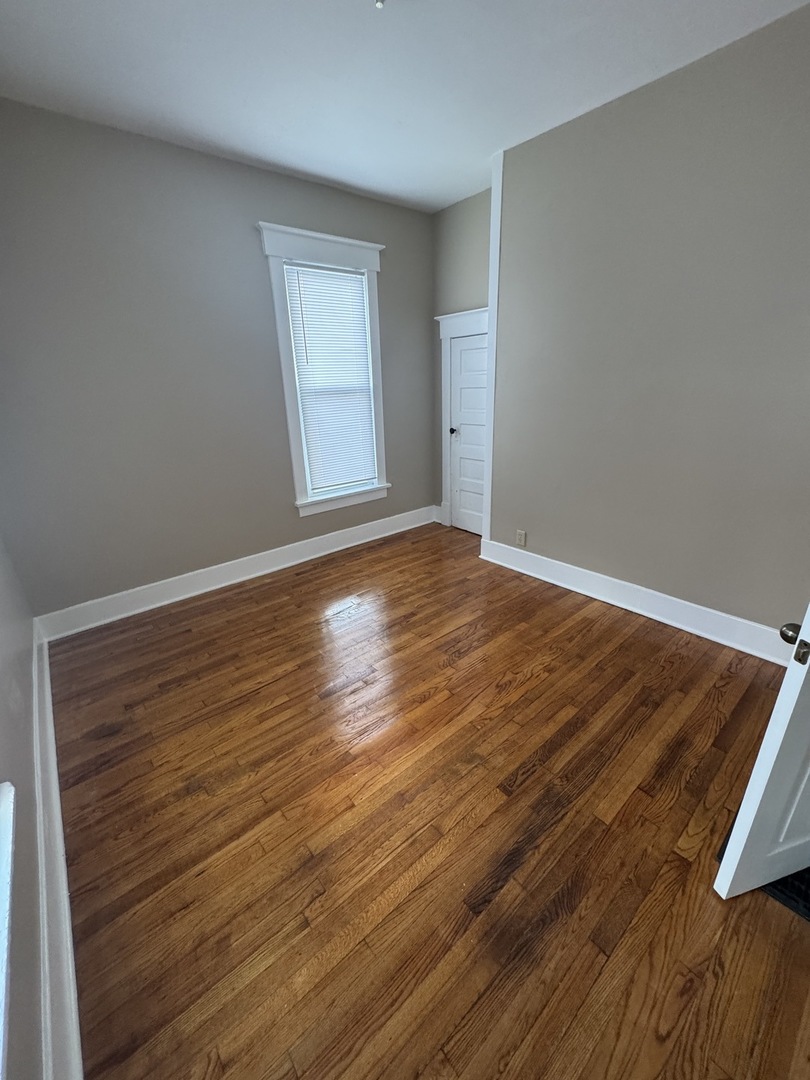 1108 East Main Street Urbana, IL 61802 - Photo 7 of 10 a view of an empty room with wooden floor and a window