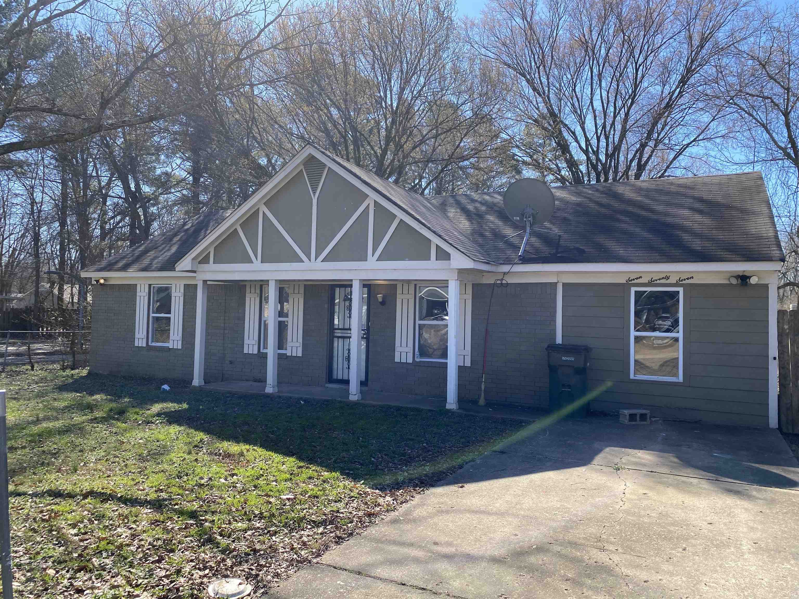 a front view of a house with a yard and trees