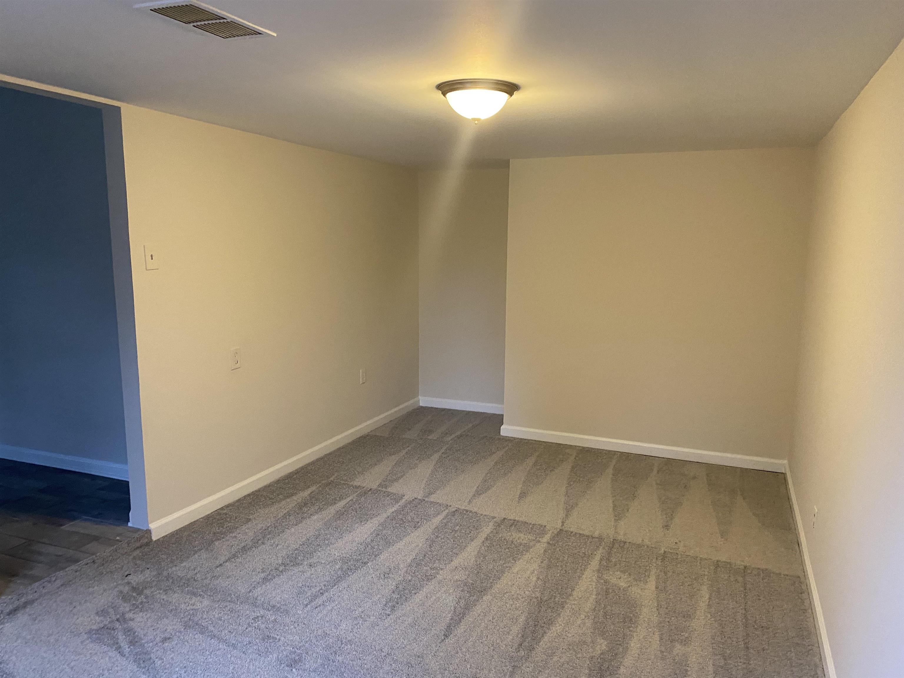 777 Archie Drive Memphis, TN 38127 - Photo 3 of 15 an empty room with wooden floor and mirror