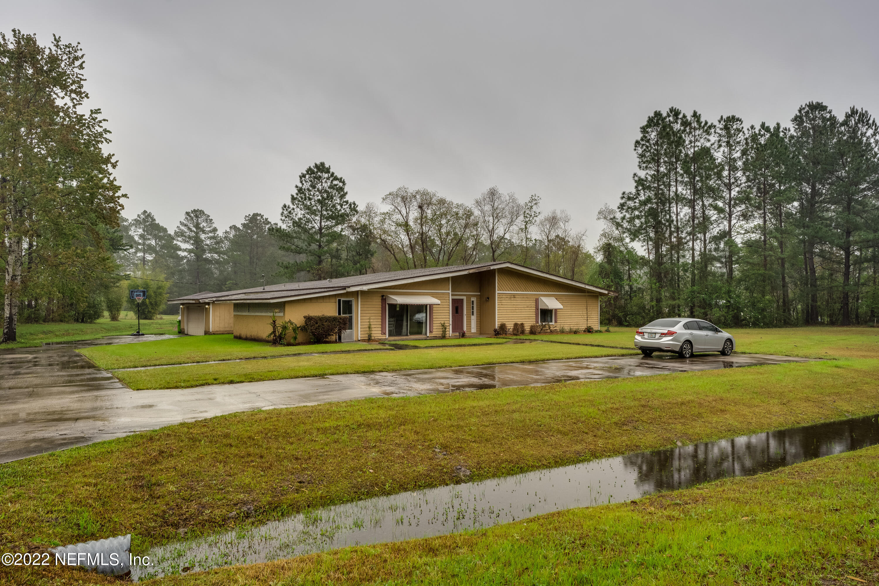 54528 Vikki Road Callahan, FL 32011 - Photo 1 of 41 a view of a house with a big yard and large trees