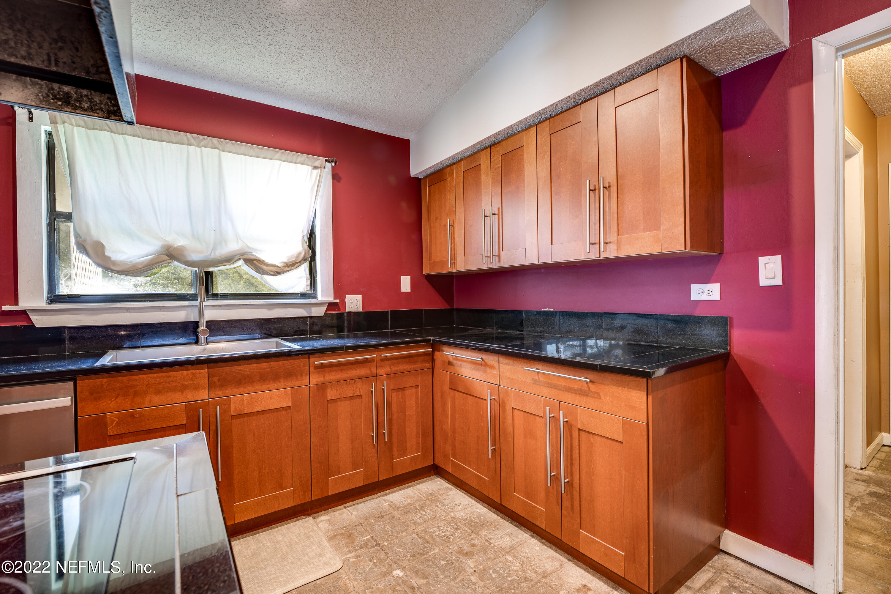 54528 Vikki Road Callahan, FL 32011 - Photo 19 of 41 a kitchen with granite countertop a sink a stove and wooden cabinets