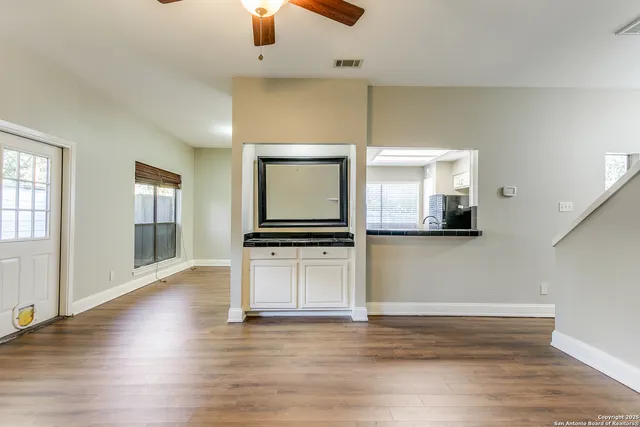 a view of a kitchen with furniture and wooden floor