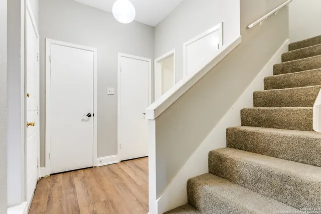 a view of hallway with stairs and wooden floor