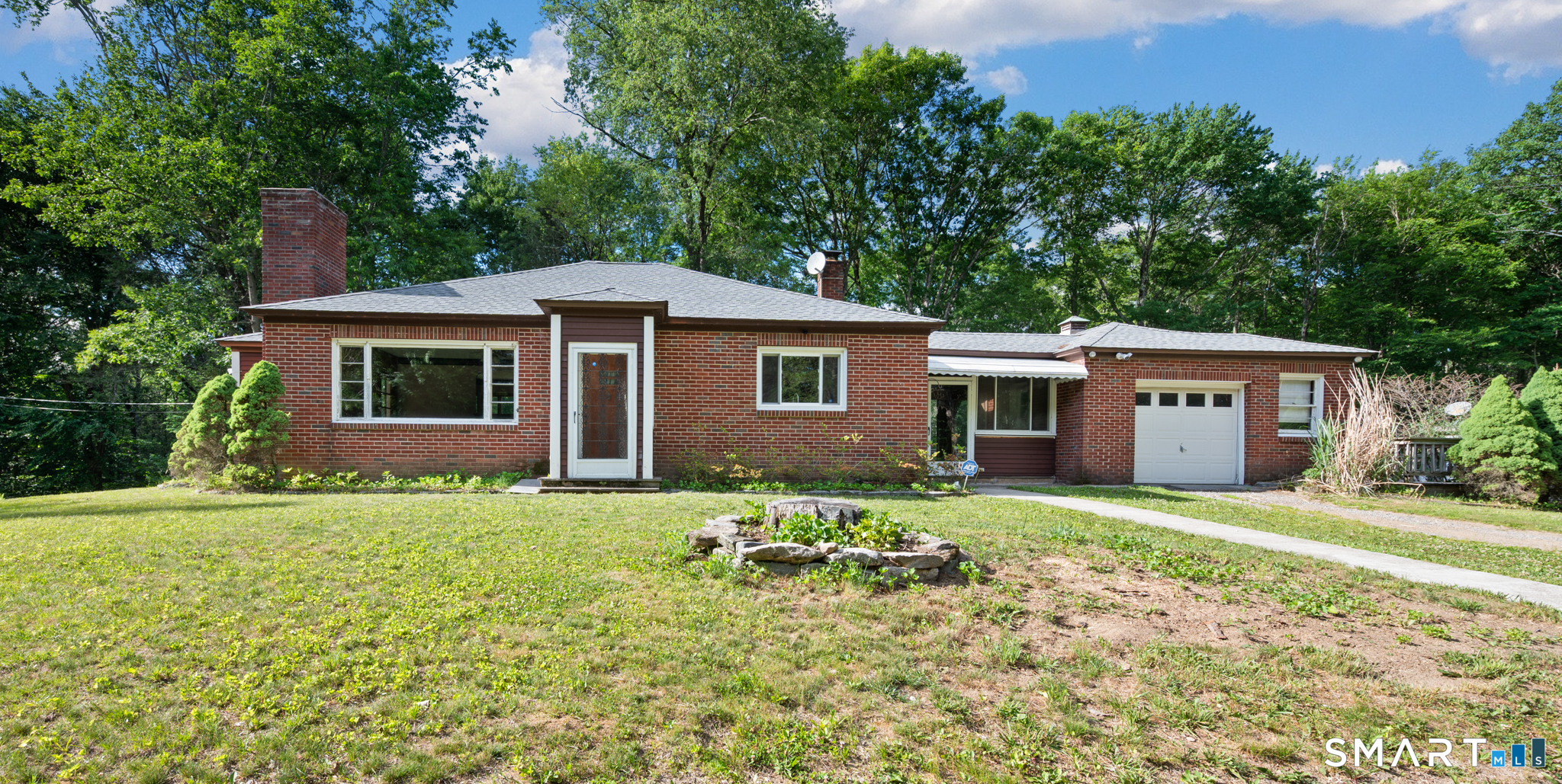 a front view of a house with a garden