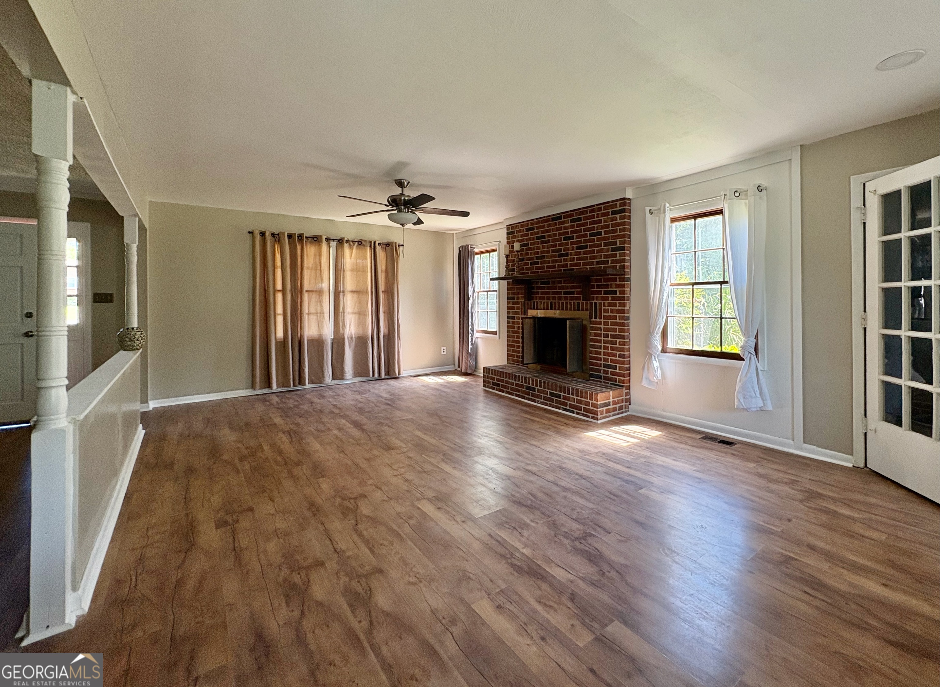 117 Laura Lane Fort Valley, GA 31030 - Photo 4 of 28 an empty room with windows fireplace and wooden floor