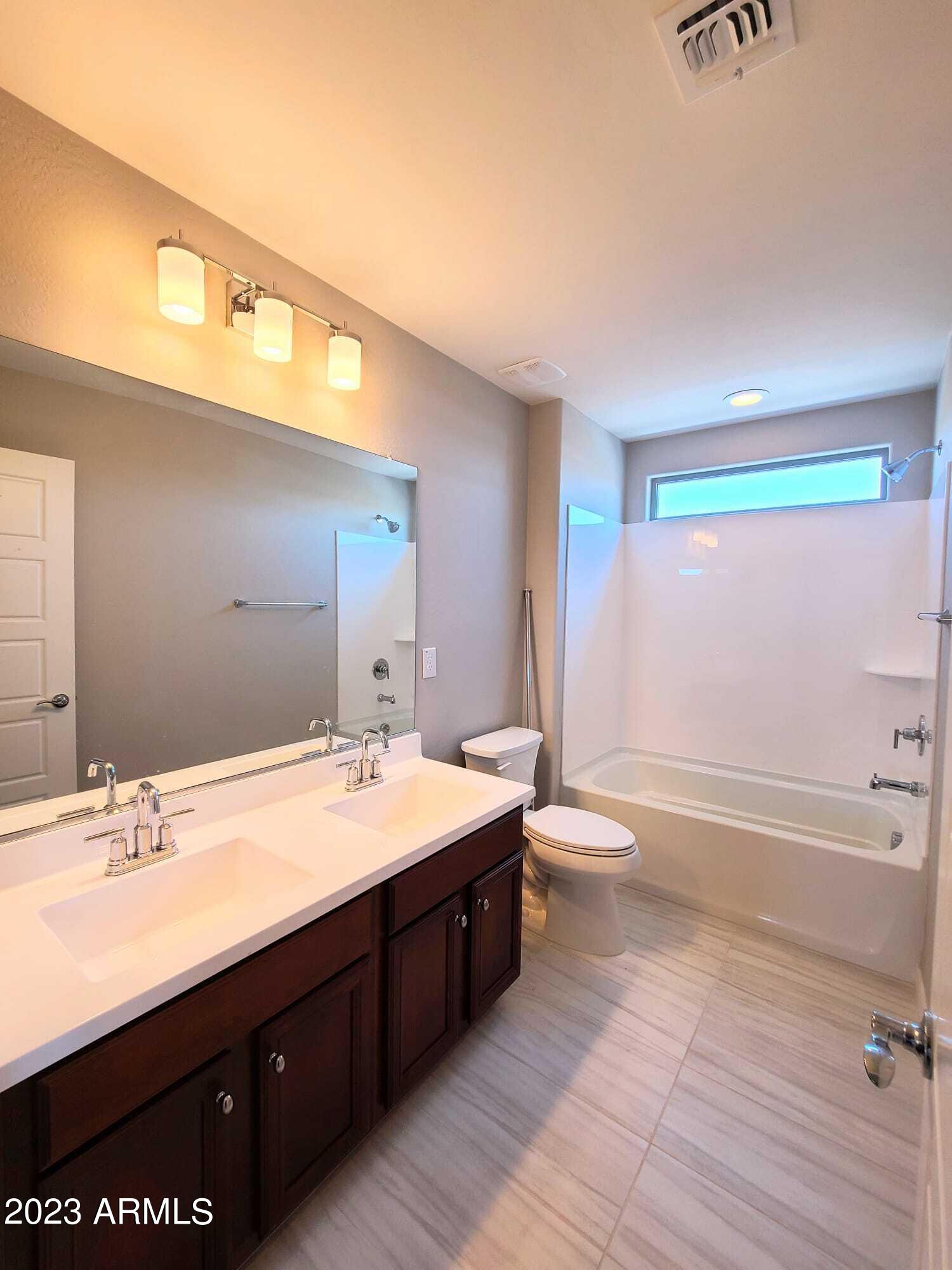 9013 West Marshall Avenue Glendale, AZ 85305 - Photo 18 of 22 a bathroom with a double vanity sink toilet mirror and bathtub