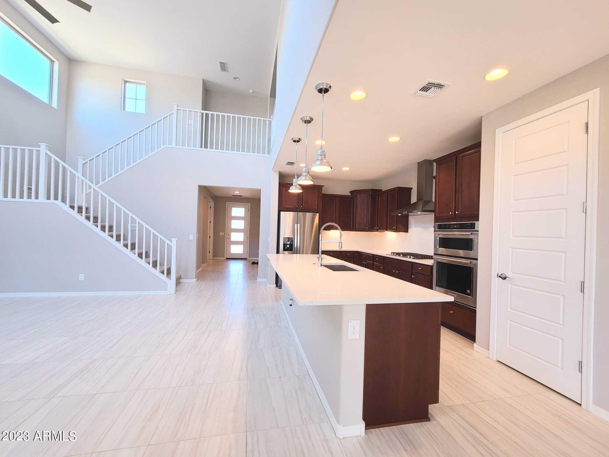 9013 West Marshall Avenue Glendale, AZ 85305 - Photo 3 of 22 a room with kitchen island stainless steel appliances wooden floor and windows