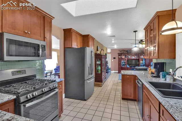 a kitchen with stainless steel appliances granite countertop a refrigerator stove and sink