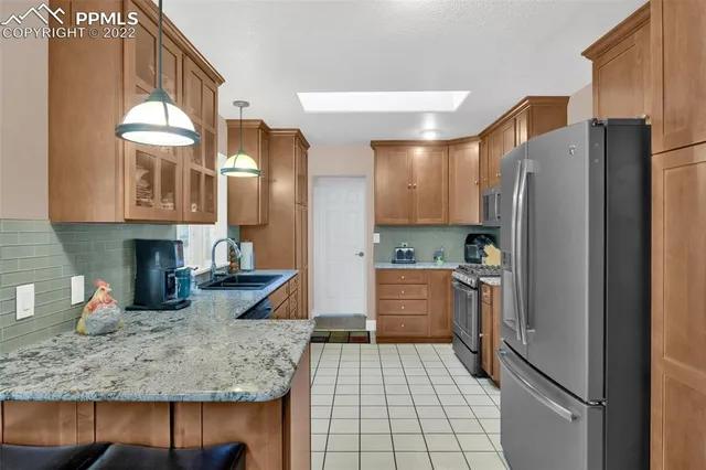a kitchen with stainless steel appliances granite countertop a refrigerator and a sink