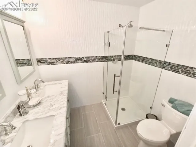 a bathroom with a granite countertop sink a toilet and a mirror