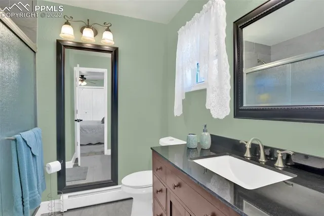 a bathroom with a toilet sink and mirror